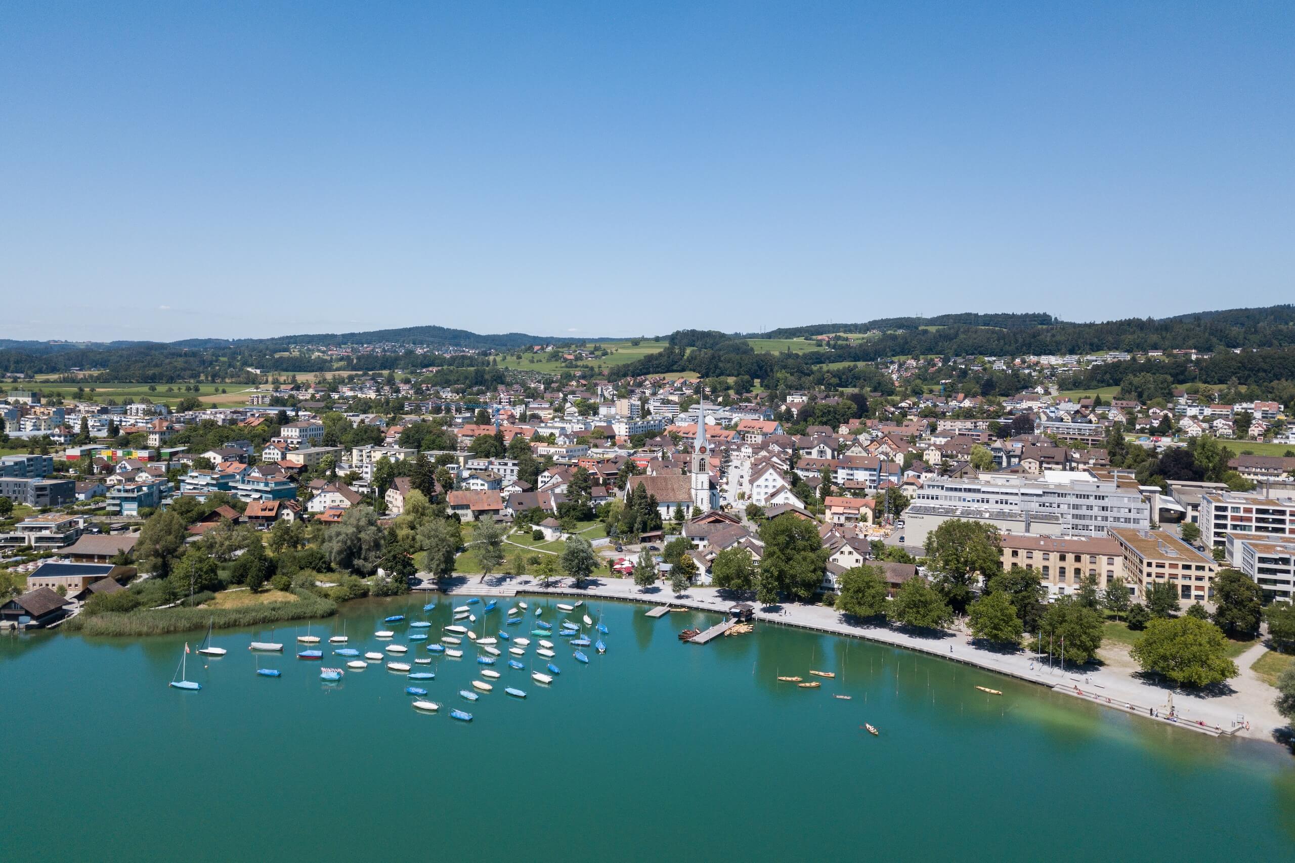 Luftaufnahme von Pfäffikon ZH mit Seeufer, Bootshafen und Altstadt im Hintergrund
