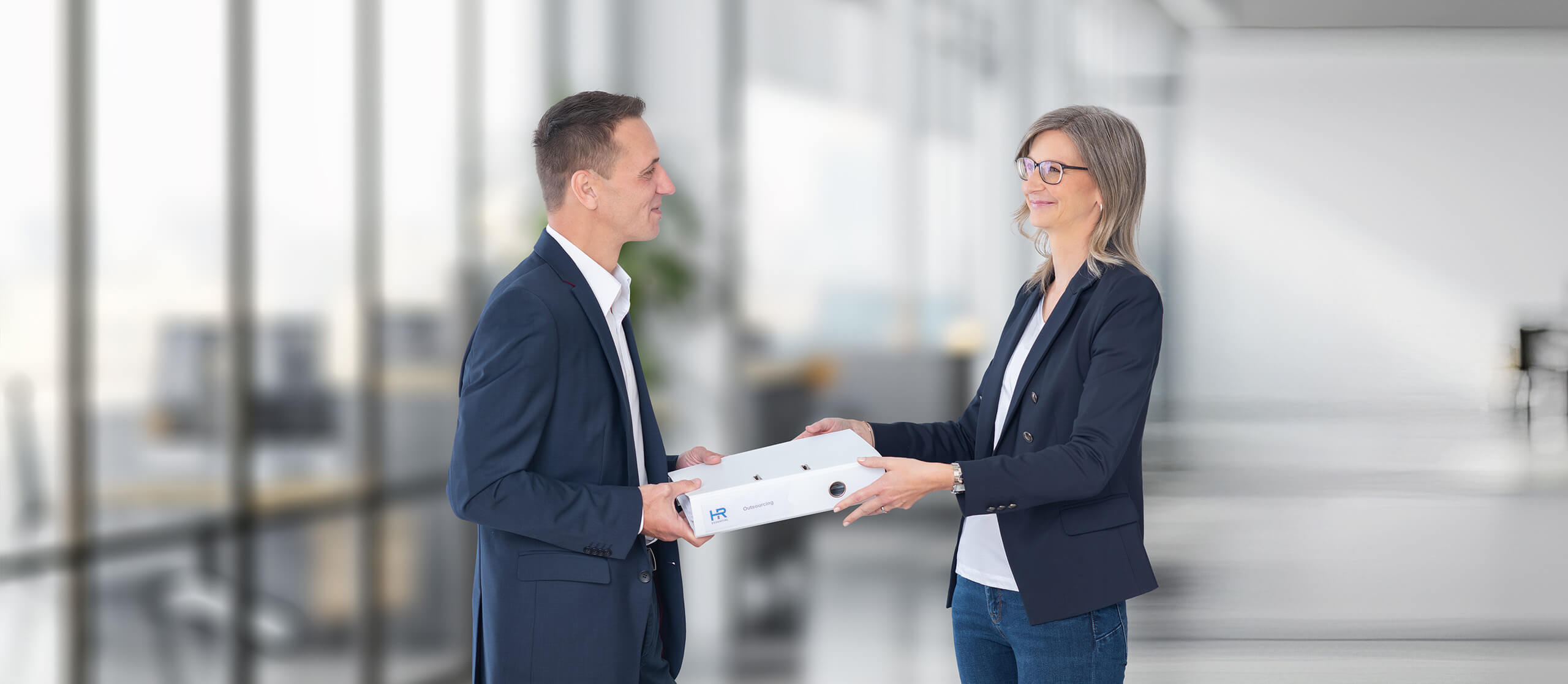 HR-Expertin Monika Lemmer bei der Übergabe von HR-Outsourcing-Unterlagen an Geschäftspartner